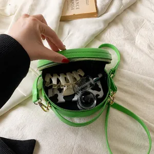 Capacité intérieure détaillée du mini sac rond vert vif montrant des objets du quotidien