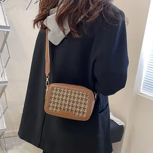 Borsa a tracolla marrone pied de poule con ampia tracolla indossata su blazer