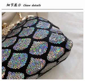 Detail of iridescent sequins on shell-shaped evening bag with diamond-encrusted metal clasp