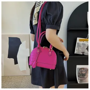 Fashionable rose pink shell bag with crocodile texture shown on female model shoulder