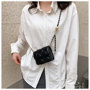 Détail du mini sac bandoulière matelassé noir avec chaîne et boule dorées