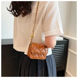 Détail d'un mini sac matelassé marron avec chaîne dorée et boule métallique ajustable