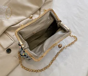 Detail view of the sequin shell bag interior with metal clasp and herringbone lining