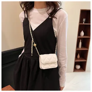 Détail d'un mini sac matelassé blanc avec bandoulière chaîne et boucle à bille dorée