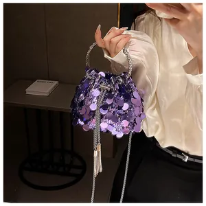 Close-up of purple sequin bucket bag featuring silver ring handles and tassel detail