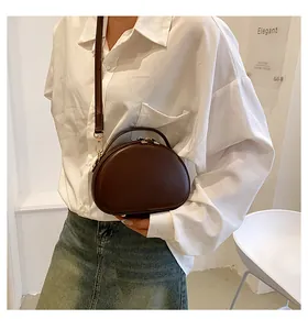 Détail d'un sac bandoulière vintage en cuir PU marron foncé avec finitions dorées