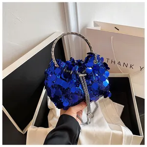 Detail of blue sequined bucket bag with silver metal handle and shiny reflective texture