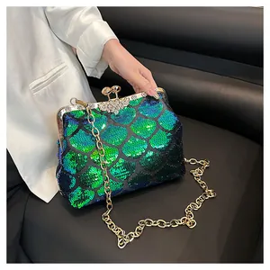 Détail de paillettes dégradées en écailles et fermoir strass sur sac de soirée chic