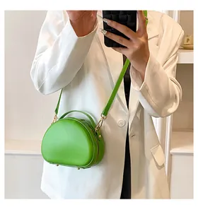 Détail du sac bandoulière demi-lune vert néon avec ferrures dorées et poignée fixe