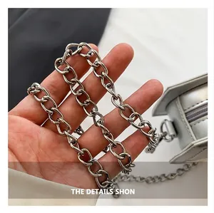 Macro detail of high-quality silver metal chain shoulder strap and polished bag fastener