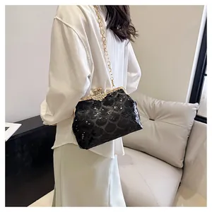 Détail du sac coquillage à paillettes noires avec fermoir doré et fleur en strass