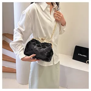 Détail du sac coquillage à paillettes noires avec fermoir clic-clac doré et chaîne