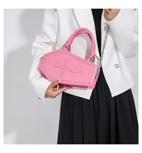 Detail of pink coffin-shaped purse with cross stitching and silver metal chain strap