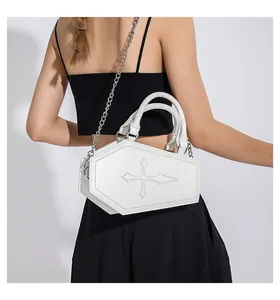 Detail of coffin-shaped white crossbody bag with cross stitching and silver metal chain