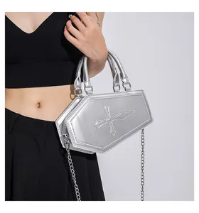 Detail of silver coffin shaped bag with cross embroidery and metallic chain strap