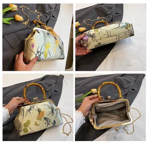 Vue détaillée du sac vintage en soie avec poignée en bambou et motif papillon