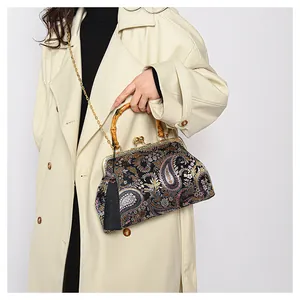 Detail der Vintage-Brokattasche mit Paisleymuster, Bambusgriff und schwarzer Quaste