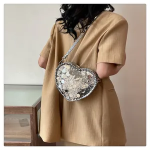 Close-up of heart-shaped crossbody bag with shimmering silver and gold sequins