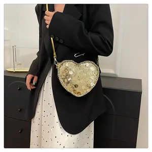 Close-up of heart-shaped crossbody bag with gold sequins and elegant metal chain strap