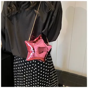 Detail of rose pink star-shaped crossbody bag with glossy metallic finish and gold chain