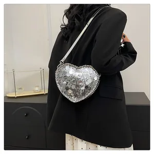 Close-up of heart-shaped shoulder bag with silver sequins and metallic chain trim