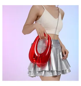 Detalle de un bolso de acrílico transparente rojo con una fina cadena plateada