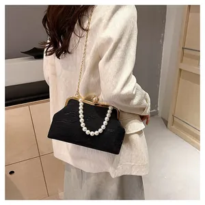 Détail du sac coquille noir vintage avec anse en perles et fermoir doré chic