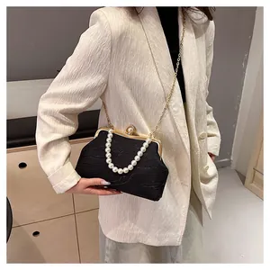 Détail du sac coquille noir élégant avec poignée en perles et chaîne dorée sur mannequin