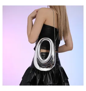 Bolso ovalado plateado metálico con cadena y asa de anillo integrada mostrado en modelo