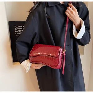 Λεπτομέρεια μπορντό τσάντα ώμου με σχέδιο κροκόδειλου, κυρτή βάση και χρυσή αγκράφα