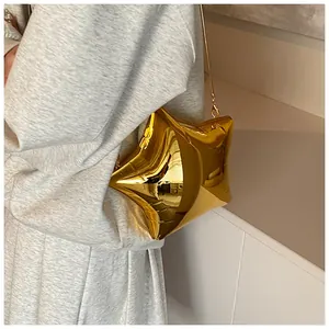 Chic star-shaped gold crossbody bag with a metal chain strap shown on a model