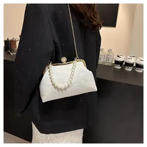 Détail du sac plissé blanc avec poignée en perles et chaîne dorée sur mannequin