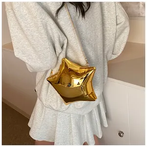 Detail of a shiny gold star-shaped crossbody bag with a sleek metal chain strap