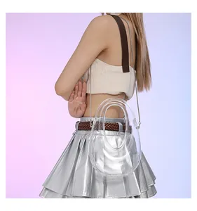 Detalle de bolso bandolera de acrílico transparente con cadena de metal llevado por modelo