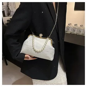Gros plan du sac blanc à texture ondulée avec poignée en perles et fermoir doré