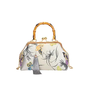 Sac rétro chinois avec poignée en bambou et broderie élégante de papillon