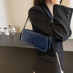 Dunkelblaue Handtasche mit Krokodilprägung, glänzender Oberfläche und goldener Schnalle