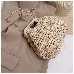 Detailed macro view of beige straw woven shell bag with elegant gold chain shoulder strap