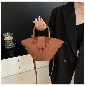 Detail of a brown vintage fan-shaped handbag with top handles and adjustable shoulder strap