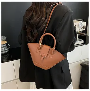 Detailed view of a caramel fan-shaped leather handbag with an adjustable shoulder strap