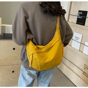 Rückansicht eines Models mit hellgelber Nylon-Halbmondtasche im lässigen Freizeitstil
