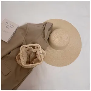 Flat lay of a beige straw beach bag with soft fabric lining and delicate metal chain strap