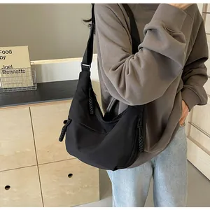 Detailansicht einer schwarzen Halbmond-Umhängetasche aus Nylon mit breitem Schultergurt