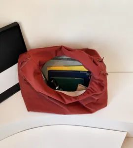 Vista interna della borsa in nylon terracotta con ampio spazio per tablet e libri
