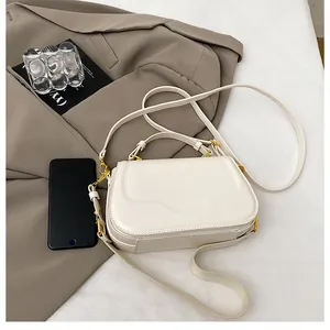 Détail du sac à main en cuir ivoire avec boucles dorées et bandoulière réglable