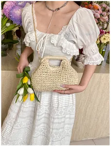 Detailed weave pattern of a beige straw shoulder bag with elegant gold chain strap