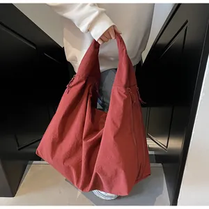 Dettaglio macro della borsa tote in nylon terracotta con trama del tessuto e coulisse