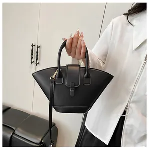 Detail of a black matte PU leather fan-shaped handbag with elegant gold hardware