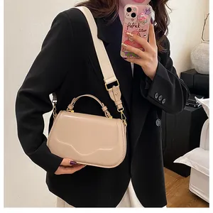 Détail du sac à main en cuir PU beige avec large bandoulière et finitions dorées sur modèle