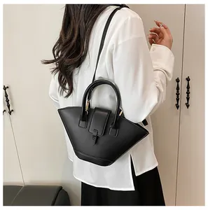 Detail of a black fan-shaped leather handbag showing its unique structure and shoulder strap